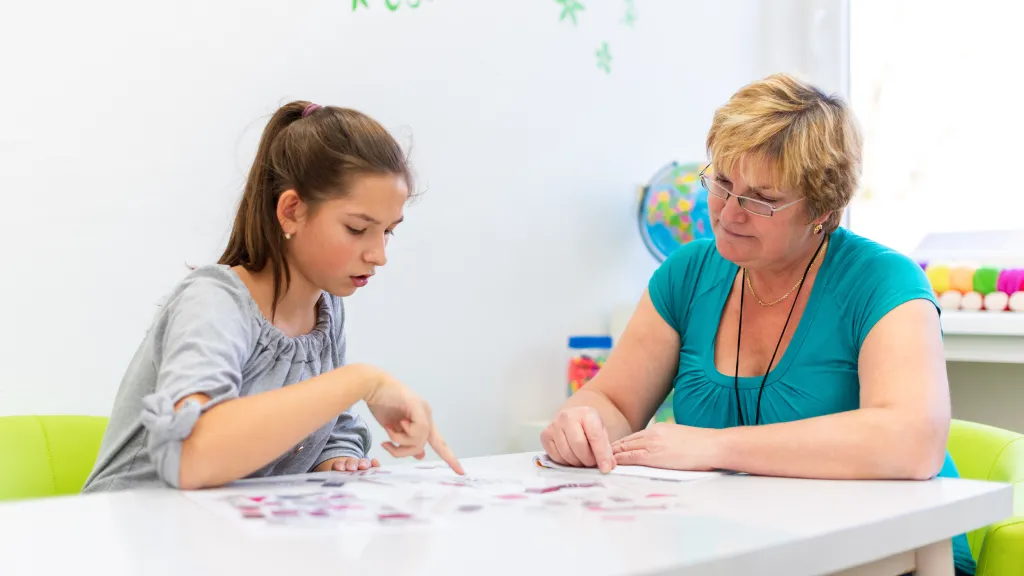 Female teacher working with a teenage student to master logic tests.
